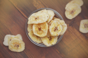 Crunchy Banana Chips on Wooden Background. Healthy Snack Fruit. Banana slices. Diet and Beauty.