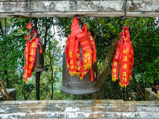 Fototapeta premium Hat Yai, Thailand - Circa December 2017: Bells decorated with Chinese ribbons at Hat Yai Park main temple