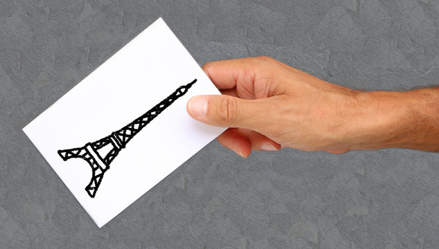 Homme tenant une carte avec la Tour Eiffel dessus