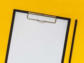 Flat lay black business accessories on yellow background with blank space for text. Top view. Copy space.