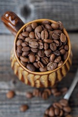 Roasted coffee beans in a clay mug 