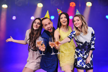 a guy and three girls rejoice and celebrate the party in the night club. Birthday, new year, corporate party, best friends