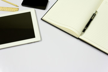 Office table with tablet, pen, smart phone, notebook on white background.
