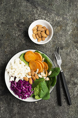 Lunch salad with spinach, sweet potato, red cabbage and young cheese with nuts of almonds..