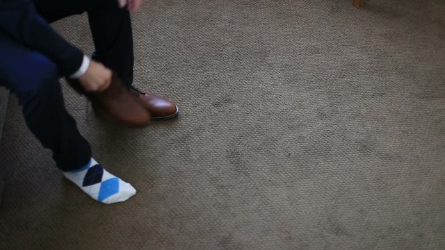 Man tying patent leather shoes formal and festive dressing.