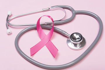 pink ribbon breast cancer and stethoscope on pink background.
