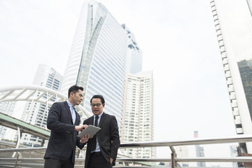 Two businessman discussing for partner business. office building background.