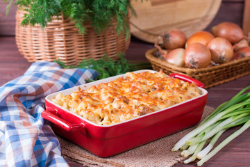 Pasta casserole with cheese and ham with tomato and cream sauce