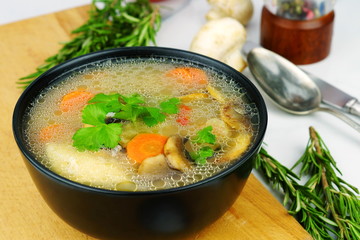 Homemade chicken soup with vegetables and mushrooms in a bowl. 