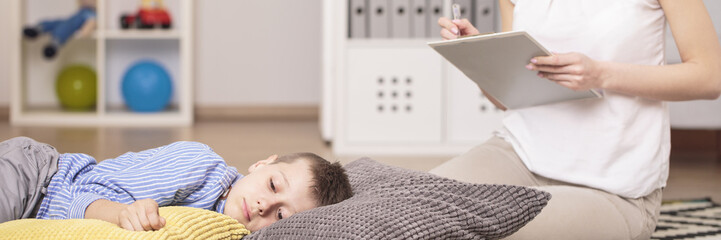 Obraz na płótnie Canvas Autistic boy lying on pillows