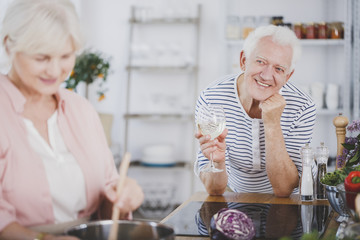 Smiling elderly man drinking wine