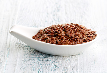 Flax seeds in white porcelain spoon