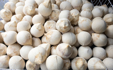 Fresh roasted young coconut on a metal basket for sell at fruit market, Mahanak, Bangkok, Thailand