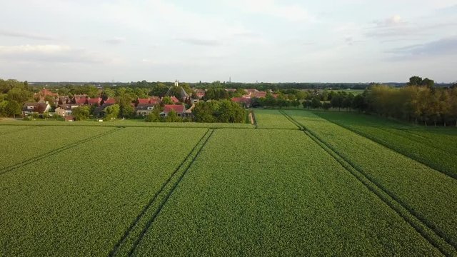An aerial of farmland in Zeeland, flying towards to small village of St Laurens.