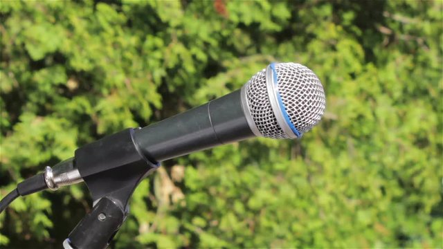 microphone on the street,Outdoor microphone without people in the background of green trees
