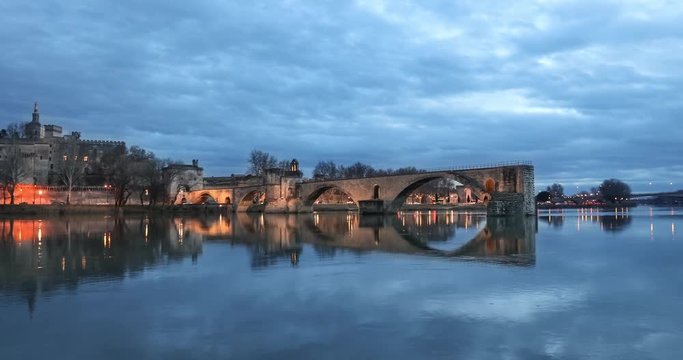 Zoom in view on Pont d'Avignon 12th century bridge and city skyline at dusk in Avignon, Provence, France
