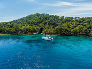 Catamaran in the background of the island. Catamaran near the island.