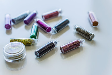 Close-up bottles of colorful glitter for makeup and manicure. Concept fashion and beauty.