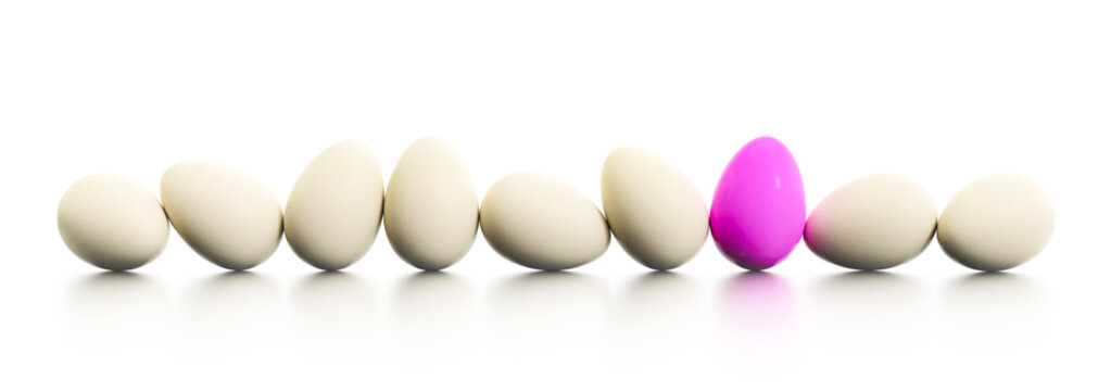 a row of easter eggs one dyed in pink