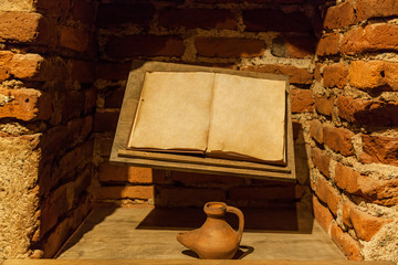 Ancient book with an inkwell near a brick wall. Ancient book with an inkwell.