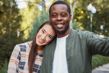 Fototapeta premium Young beautiful couple making selfie at park