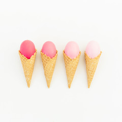 Pink Easter eggs in waffle cone on white background. Flat lay. Top view. Creative holiday concept.