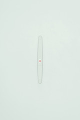 top view of pregnancy test with two lines isolated on white