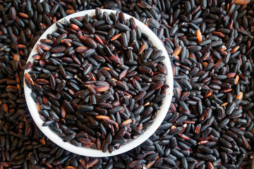Texture of Coarse black rice in white plate The concept of proper nutrition and healthy lifestyle. Top view, close-up as background or texture