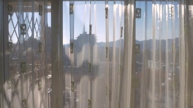 Albania, Tirana. Roller Blind and Curtain open the View from the Window