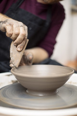 Artist makes clay pottery on a spin wheel