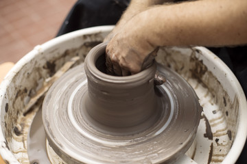 Artist makes clay pottery on a spin wheel