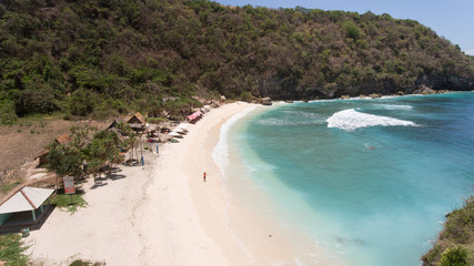 Fototapeta na wymiar Aerial view of beautiful white sand Atuh beach for relax. Clear blue ocean waves rolling to the beach. Nusa Penida, Bali, Indonesia. Travel concept.