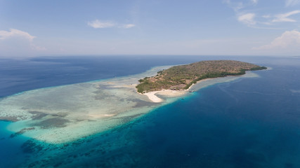 Aerial view tropical island Menjanga with white sand beach. Coral reef, atoll on Menjangan, colorful reef and perfect snorkeling and scuba diving. Seascape, ocean and beautiful beach paradise. Travel