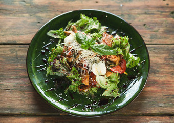 Caesar salad with quail eggs and chicken meat