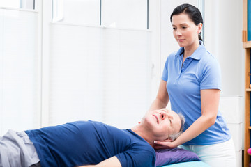 Elderly man getting massage from physio