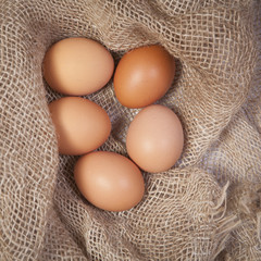 the Yellow eggs lie on a canvas on a white wooden table.