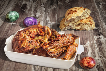Freshly Oven Baked Lamb Shoulder In Porcelain Casserole Served With Leavened Pitta Flatbread And Decorated Colorful Easter Eggs On Old Lacquered Cracked Flaky Garden Table