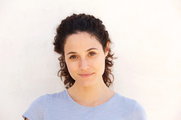 Close up attractive young woman against white wall