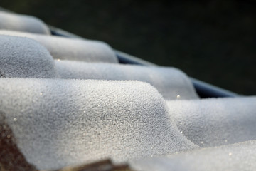 Frozen house roof covered by ice crystals