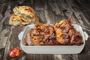 Freshly Oven Baked Lamb Shoulder In Porcelain Casserole Served With Leavened Pitta Flatbread And Decorated Red Dyed Easter Egg On Old Lacquered Cracked Flaky Garden Table