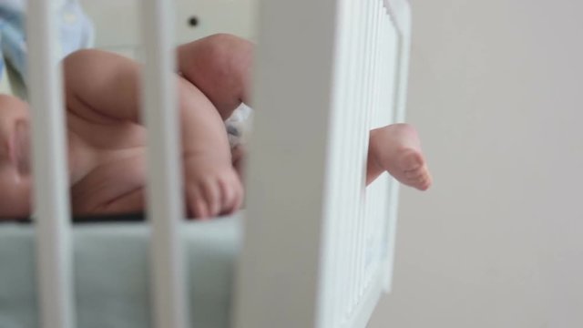Close up of a little baby boy toes and fingers, baby lying in baby cot
