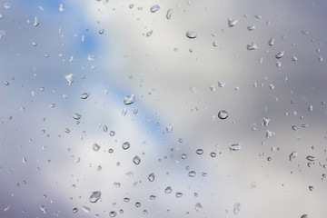drops of rain on clear glass, far away blurred sky