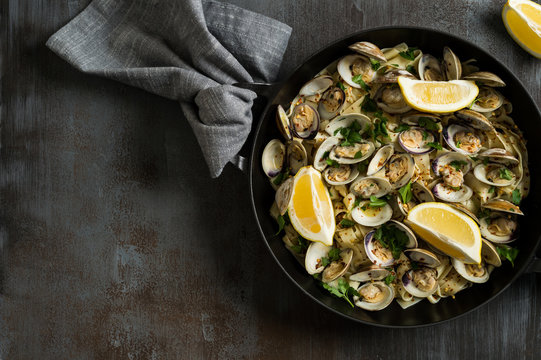 Close-up of steamed clams, linguini and parsley served in casserole