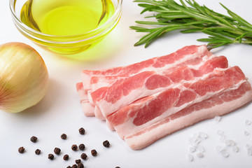 Raw bacon slices with condiments
