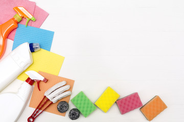 Cleaning concept with supplies on white wooden background