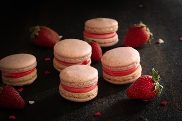 Homemade Strawberry pink French Macaroon on black background, selective focus