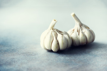Garlic, rosemary, black pepper, salt on grey concrete background. Top view, copy space.