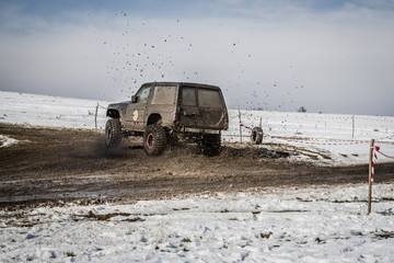 Off road truck drifting on dirt track in winter