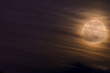 Night Sky With Bright Supermoon Phenomenon With Clouds At Front