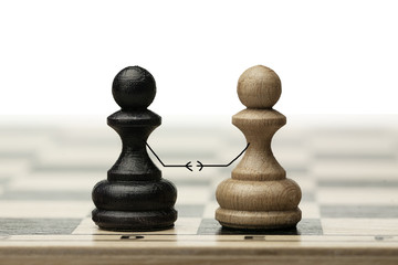 A pair of enemies reconciles and shakes hands at a meeting. Made from chess pawns